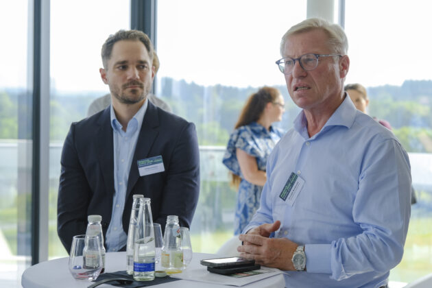 Menschen in Business-Casual-Kleidung unterhalten sich auf einem Firmen Event.