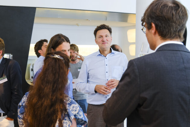 Menschen in Business-Casual-Kleidung unterhalten sich auf einem Firmen Event.