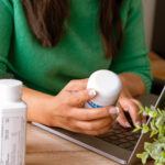 Symbilbild "Surging drug approvals" (Health and nutrition concept. Indoor image young female holding food supplement bottle sitting with laptop surfing searching internet for online review of food supplements products on internet.) Copyright: Praewphan - stock.adobe.com